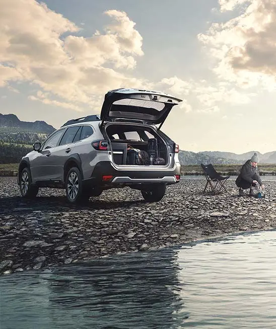 Brilliant Bronze Metallic Subaru Outback boot open at the beach